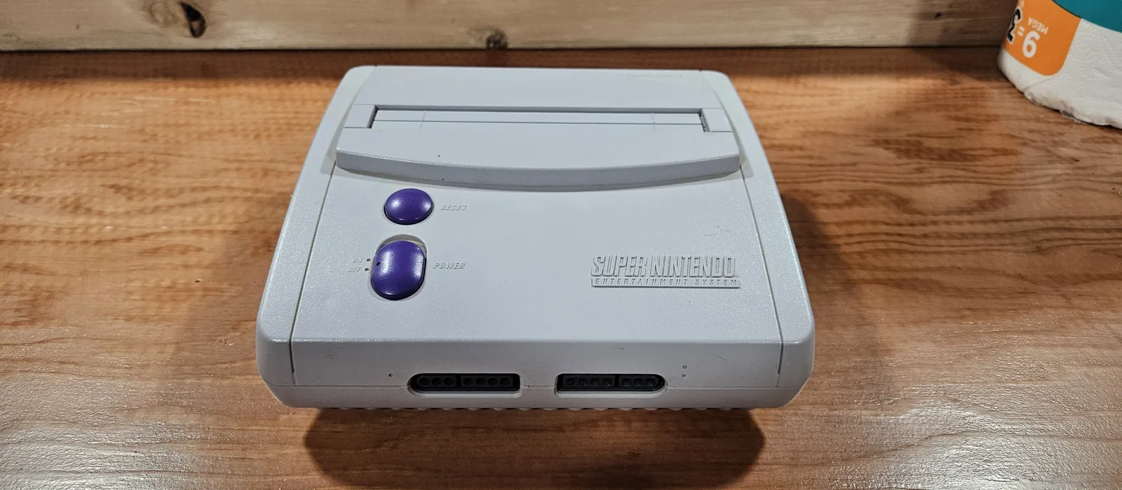 Console Super Nintendo posée sur un meuble en bois