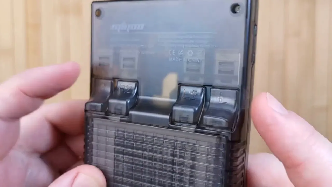Dos de la Miyoo Mini Plus en coque translucide fumée, composants visibles