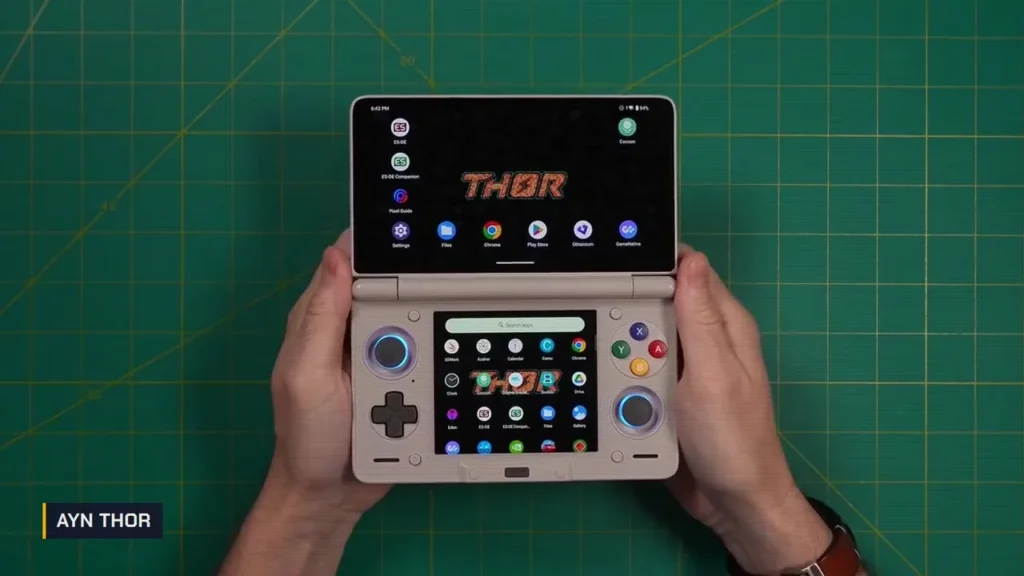 AYN Thor beige ouverte tenue à deux mains, logo THOR sur l'écran du haut et menu Android sur l'écran du bas